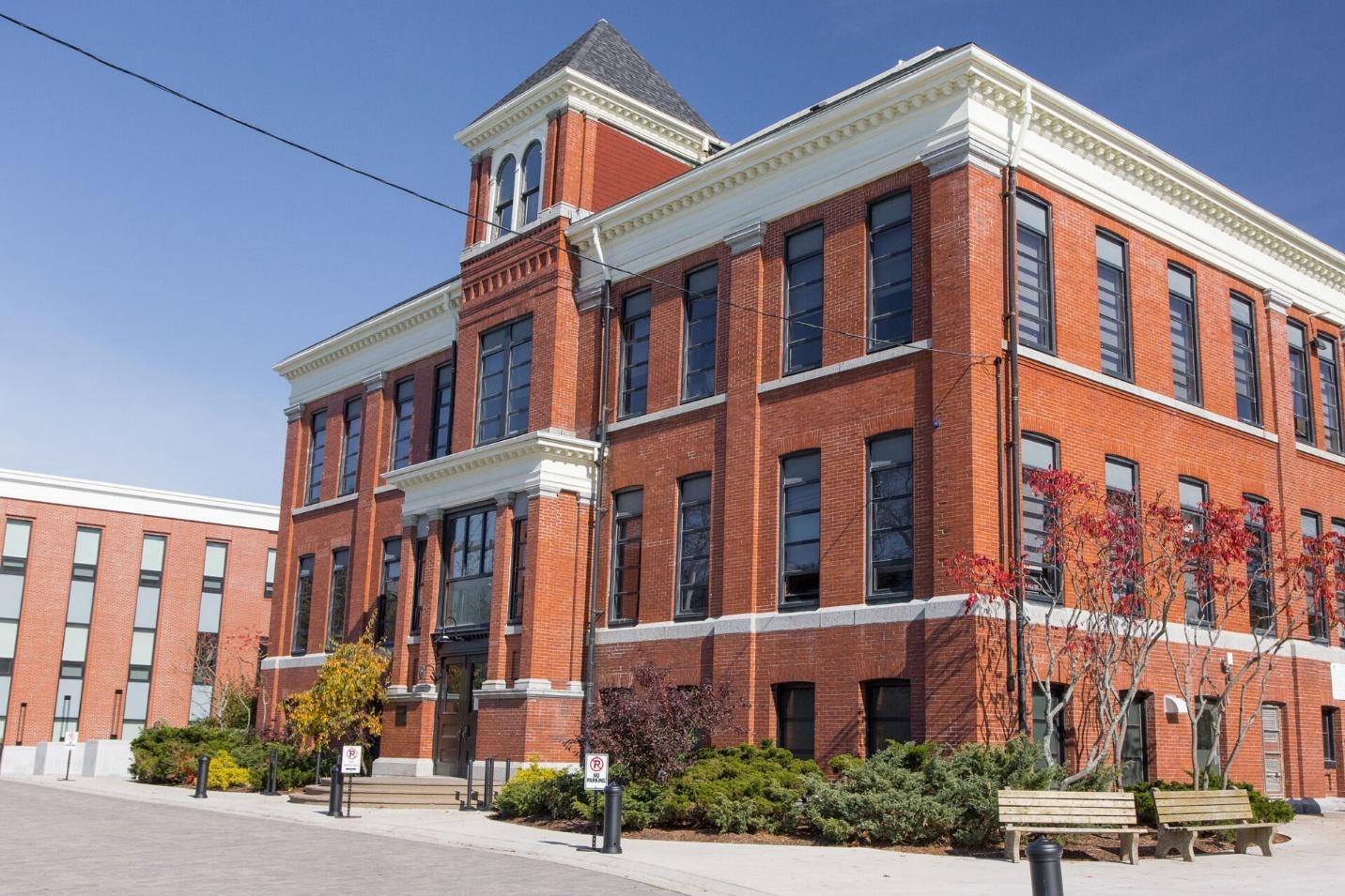 A large brick building with a white roof
AI-generated content may be incorrect.